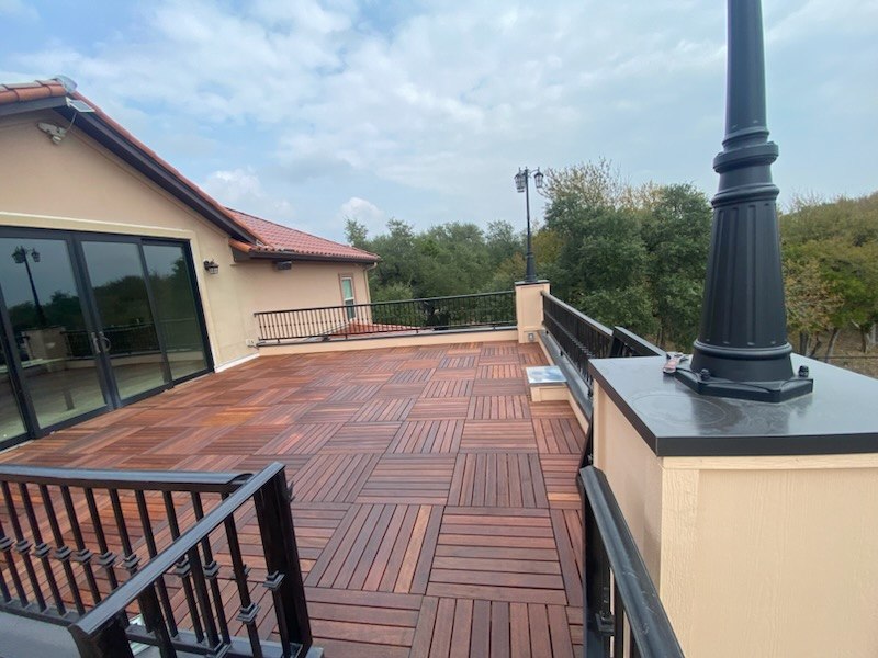 Elevated deck finished with interlocking wood tiles and metal railing