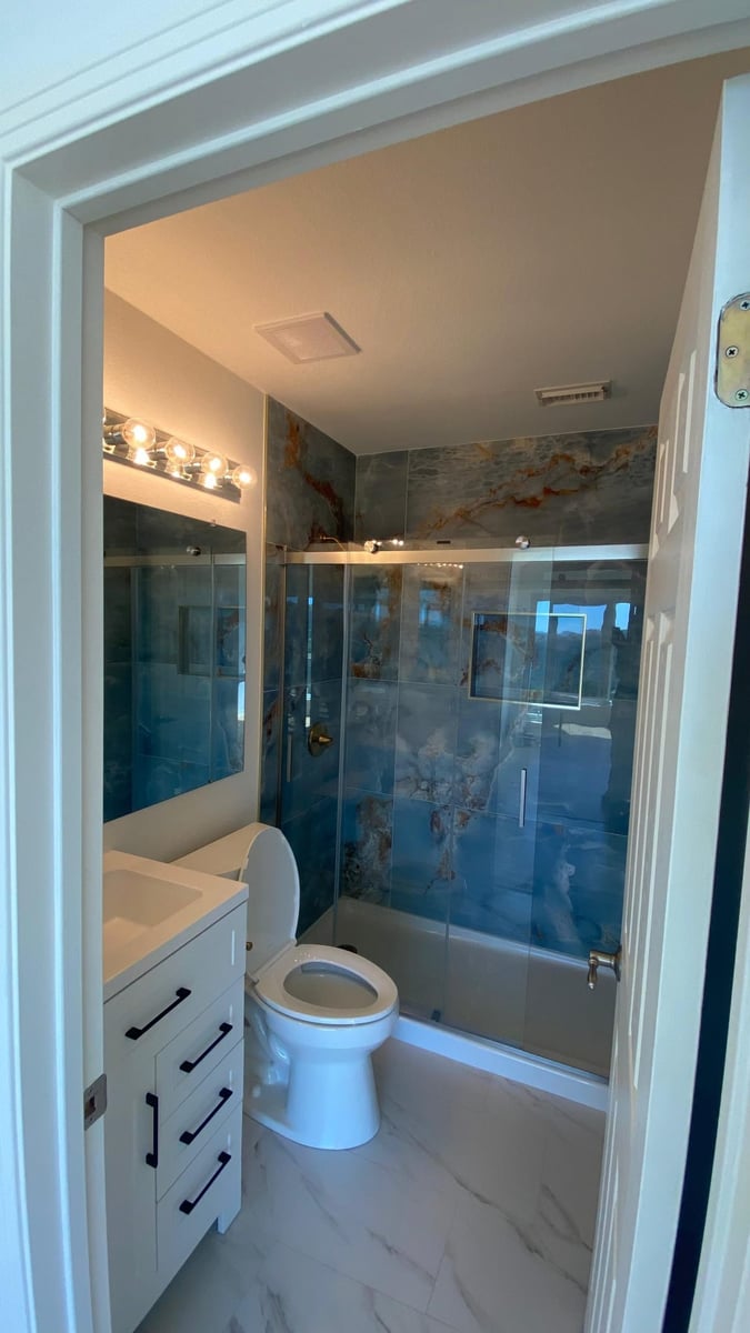 Blue marble shower renovation with glass enclosure
